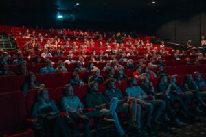 Publikum sitzt während einer Filmvorführung in einem voll besetzten Kinosaal